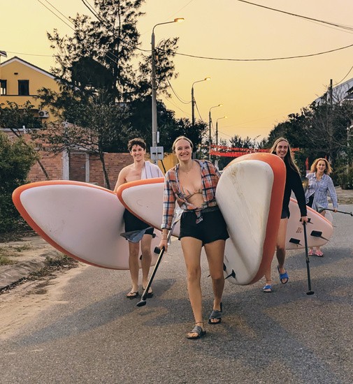 Freunde tragen ihre SUP-Boards zum Wasser